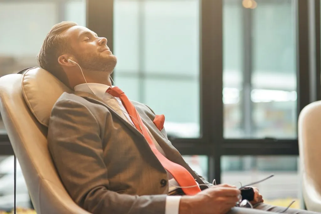 Professional businessman having a nap in the departure lounge